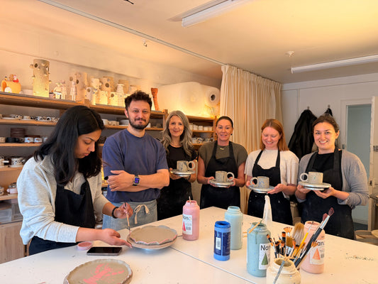 Colleagues hand-building ceramic pieces together during a corporate team-building workshop, Doppiocotto London