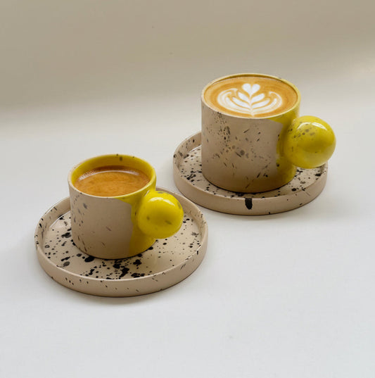 Handmade beige yellow stoneware cup and saucer set with ball handle