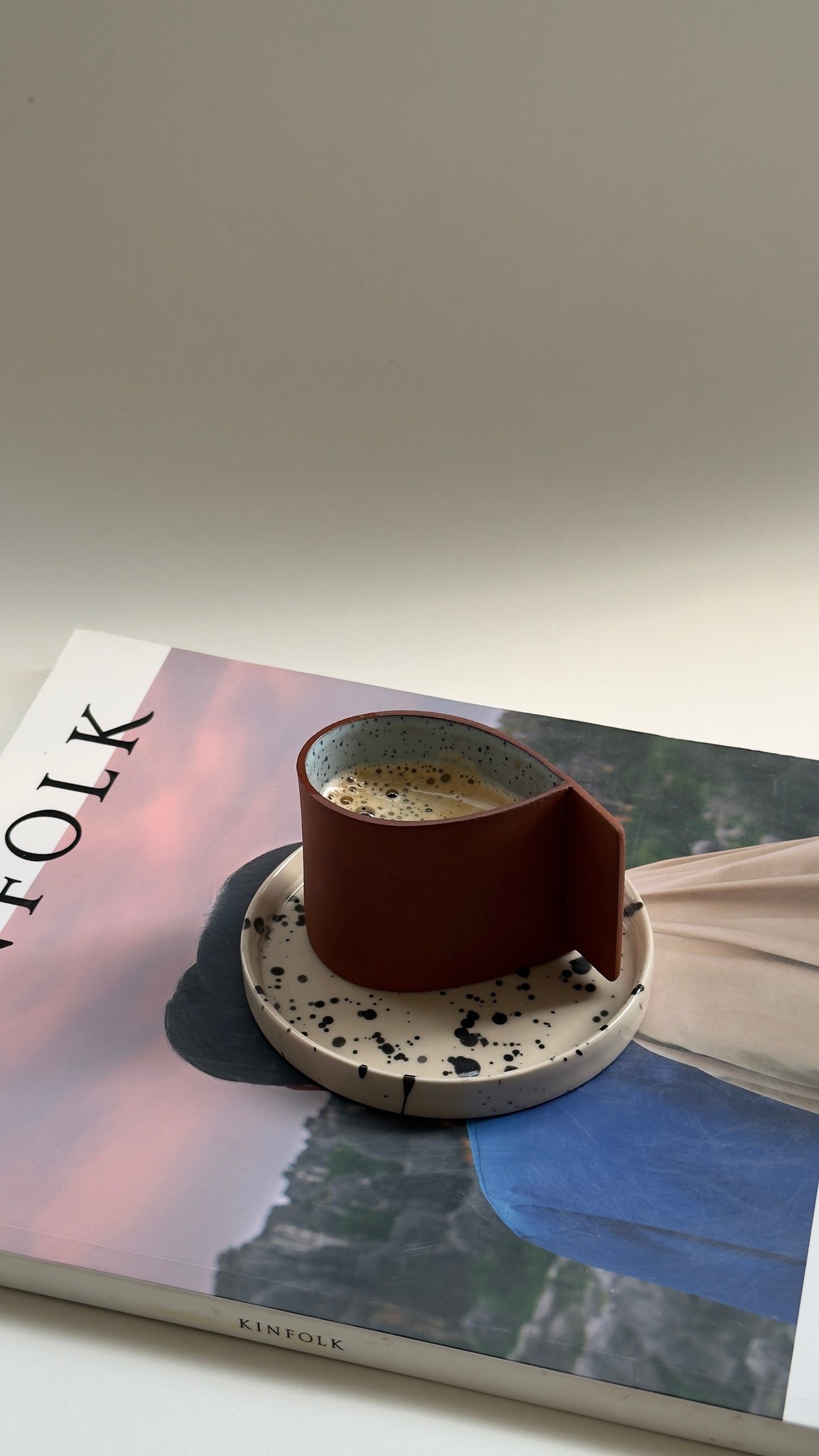 Terracotta coffee cup featuring a handmade blue drop design