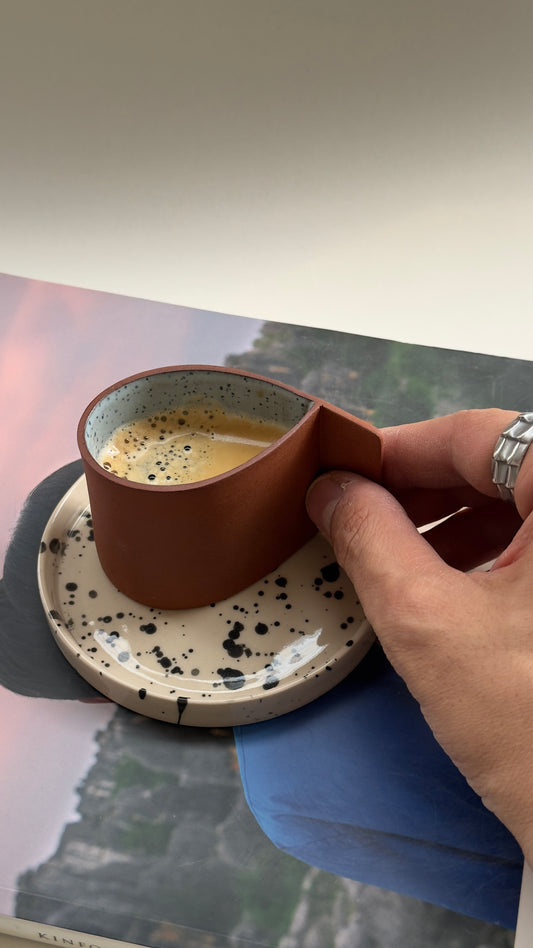 Handmade terracotta espresso cup with matching beige saucer