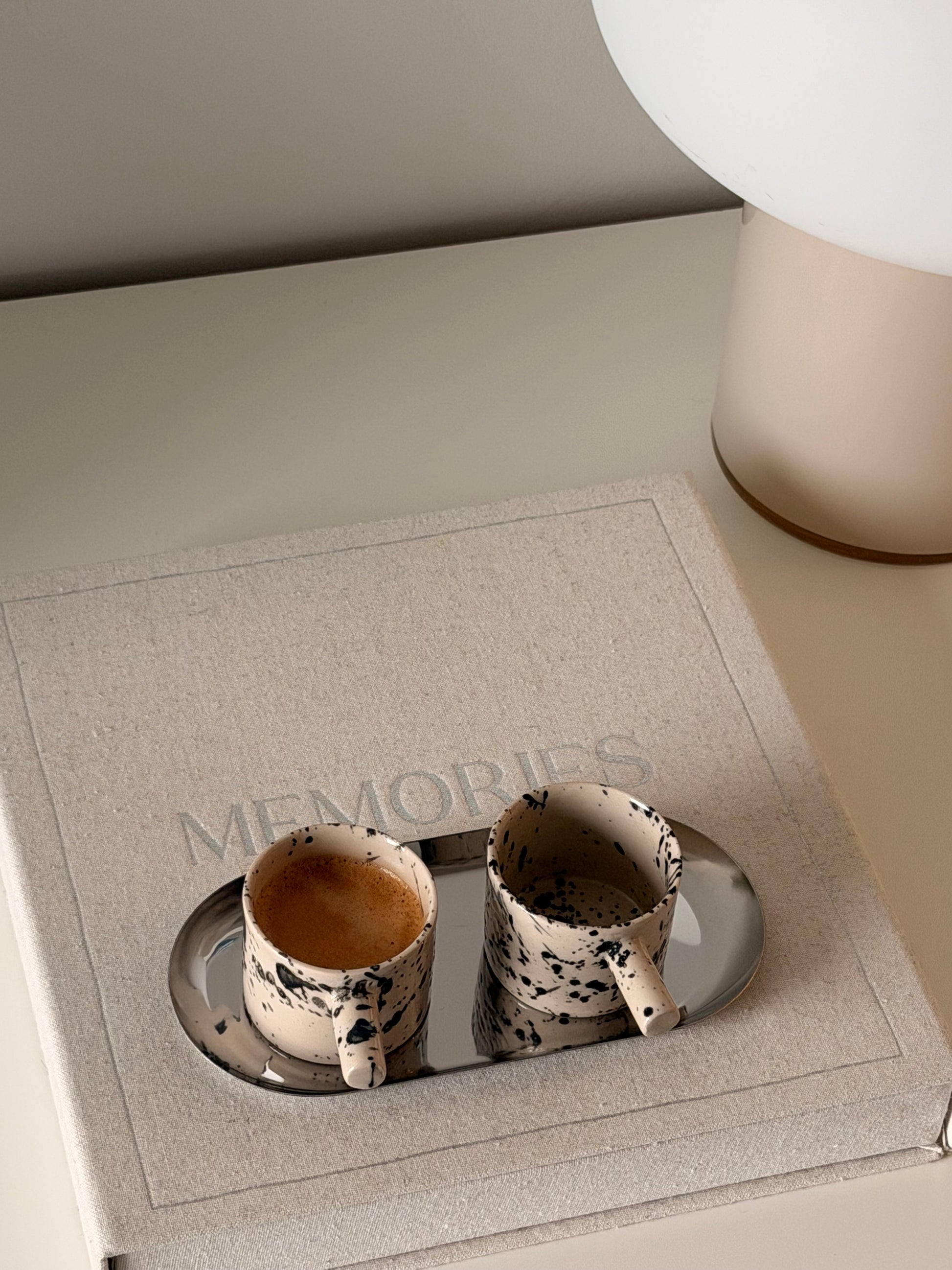 Handmade ceramic espresso cups with black splash glaze and coffee