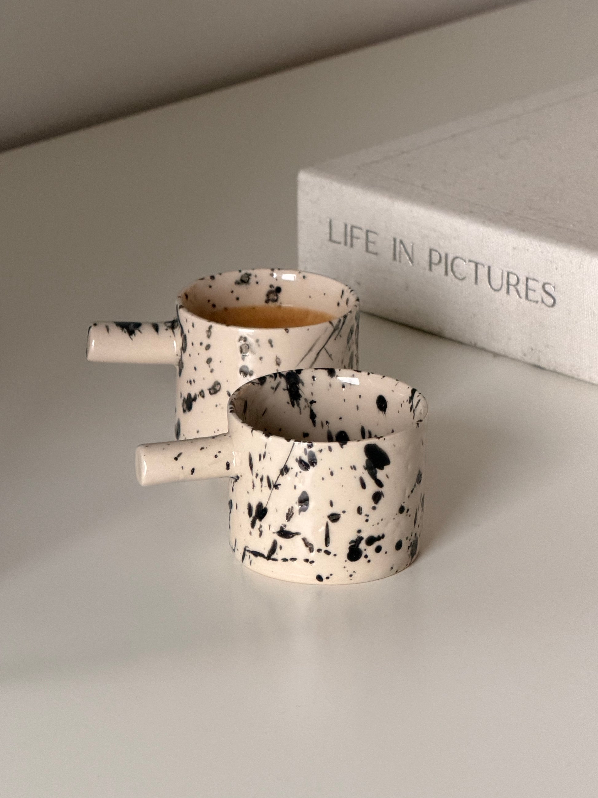 Handmade stoneware coffee cups with black splash decoration