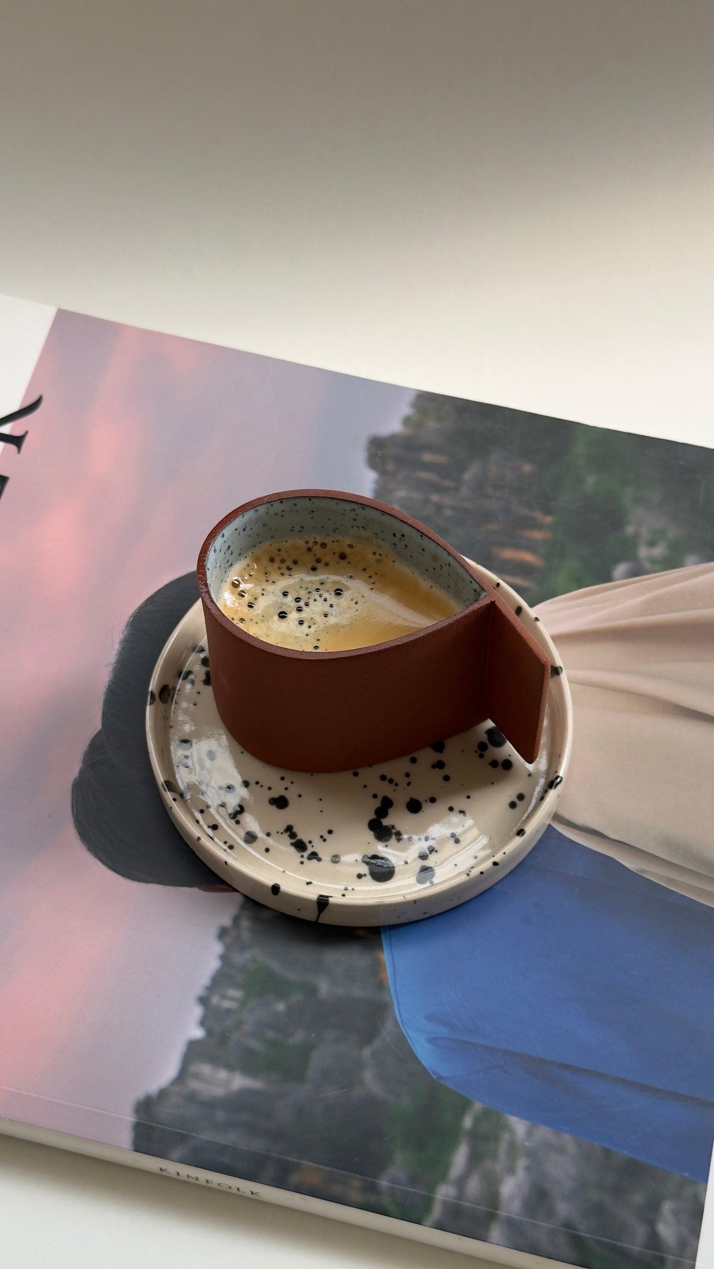 Terracotta espresso cup with blue drop detail and beige saucer