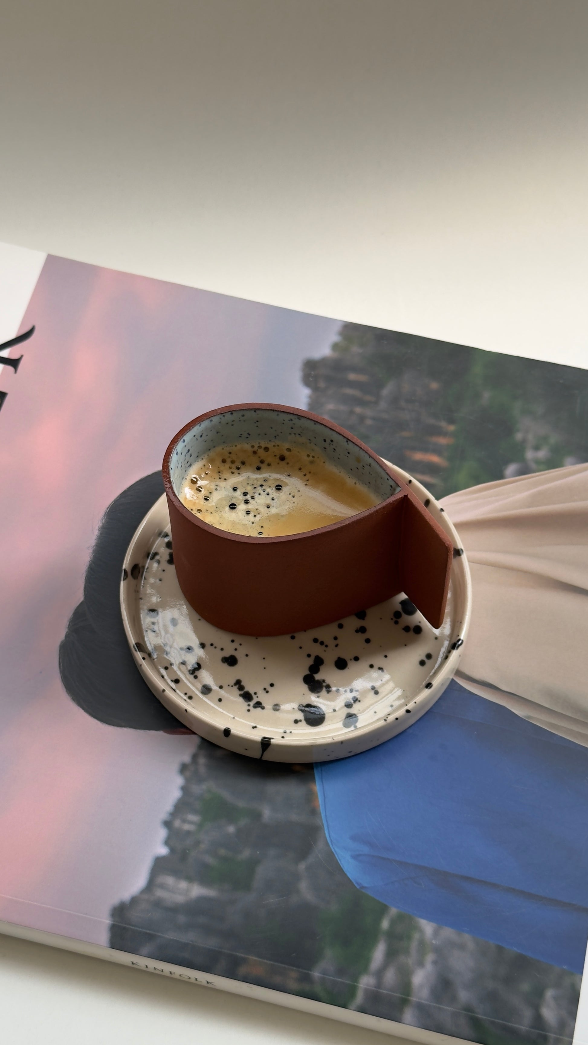Terracotta espresso cup with blue drop detail and beige saucer